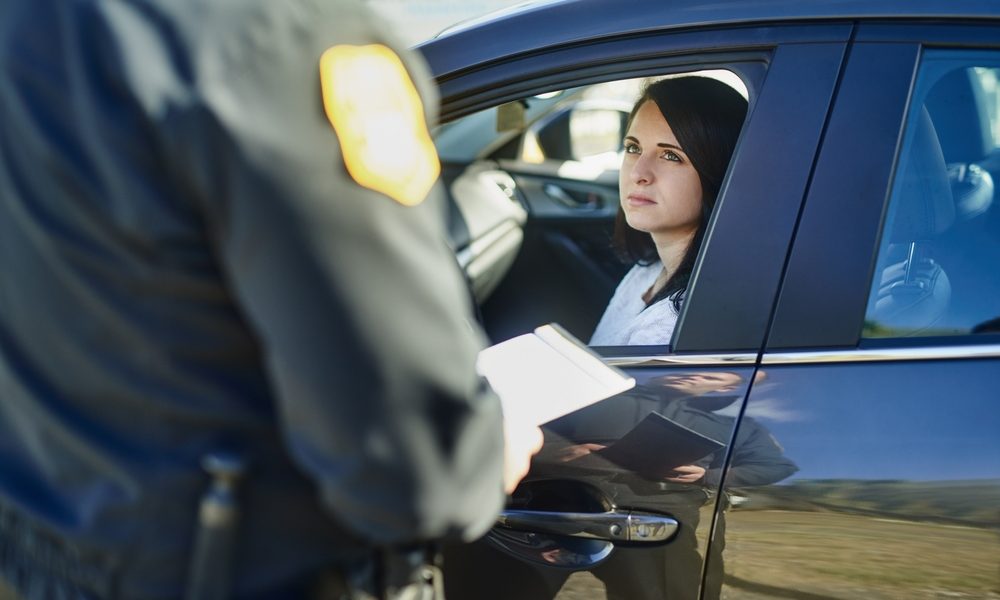 What to Say (and Not Say) to the Police During a DUI Stop | woman and traffic officer with ticket for checkpoint